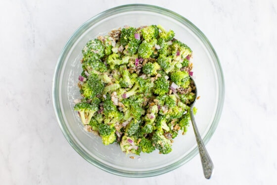 Vegan broccoli raisin salad all mixed together in a large mixing bowl.