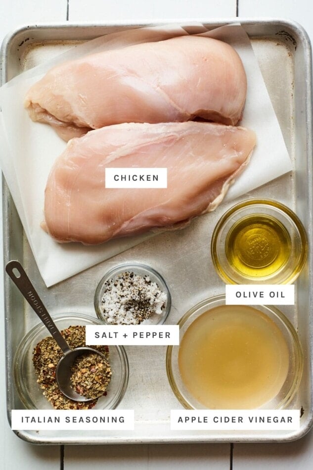 Chicken, olive oil, italian seasoning, apple cider vinegar and salt and pepper measured out.