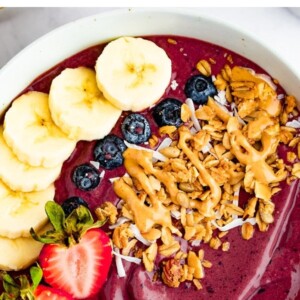 Acai bowl topped with banana, blueberries, strawberries, granola and peanut butter.