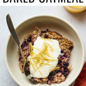 Serving of blueberry lemon baked oatmeal in a bowl and topped with yogurt and lemon zest.