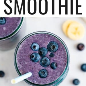 Blueberry smoothie topped with blueberries and a straw.
