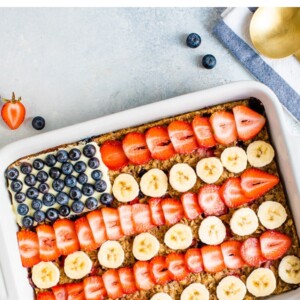 Baked oatmeal decorated to look like the American flag with blueberries, banana slices and strawberries.