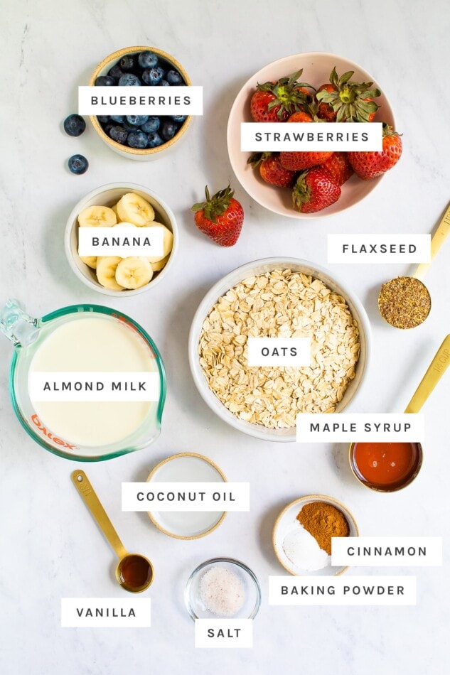 Berries, banana, oats, almond milk and other ingredients measured out to make baked oatmeal.