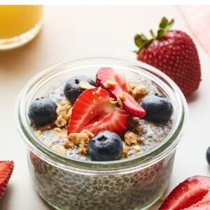 Jar of chia pudding topped with berries and granola.