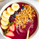 Acai bowl topped with banana, blueberries, strawberries, granola and peanut butter.