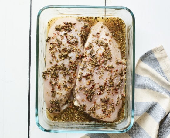 Two chicken breast being marinated in apple cider vinegar mixture.