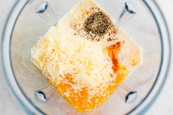 Blender with cheese, eggs, and spices.