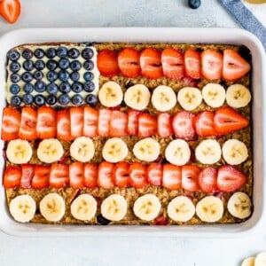 Baked oatmeal decorated to look like the American flag with blueberries, banana slices and strawberries.
