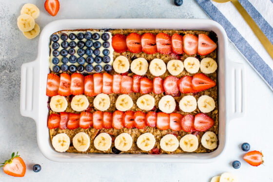 Baked oatmeal decorated to look like the American flag with blueberries, banana slices and strawberries.