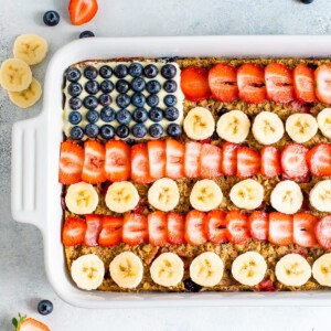 Baked oatmeal decorated to look like the American flag with blueberries, banana slices and strawberries.