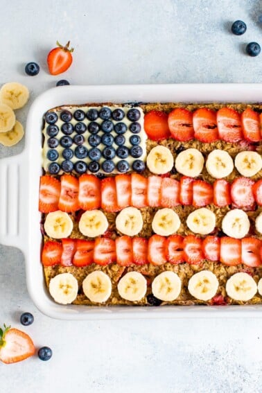 Baked oatmeal decorated to look like the American flag with blueberries, banana slices and strawberries.