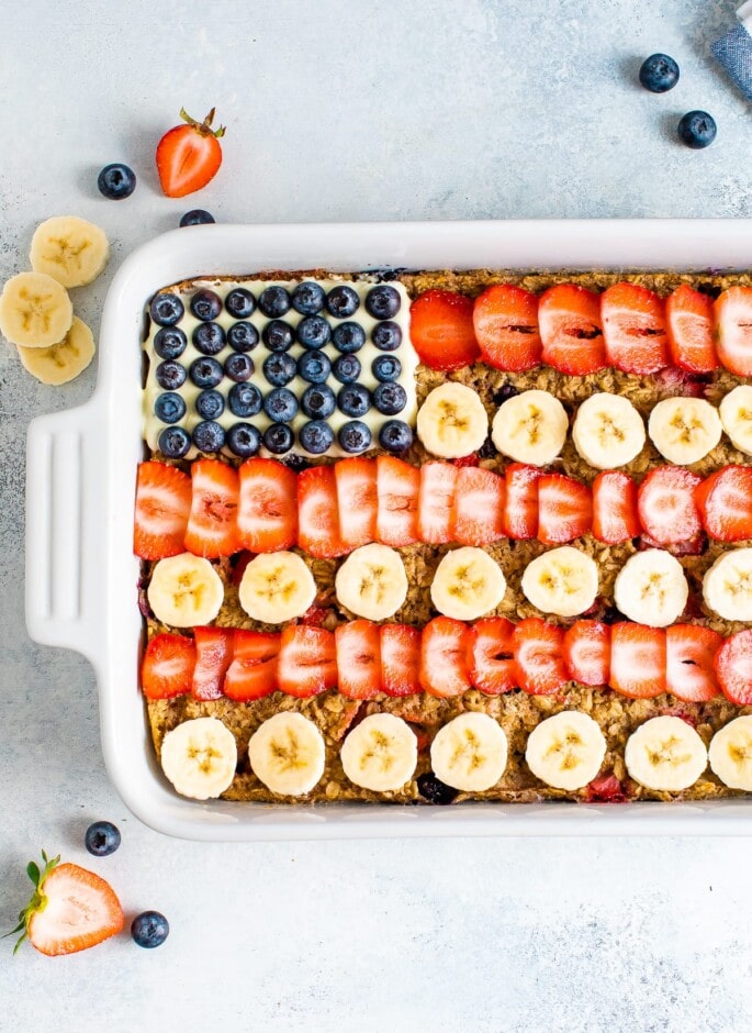 Baked oatmeal decorated to look like the American flag with blueberries, banana slices and strawberries.