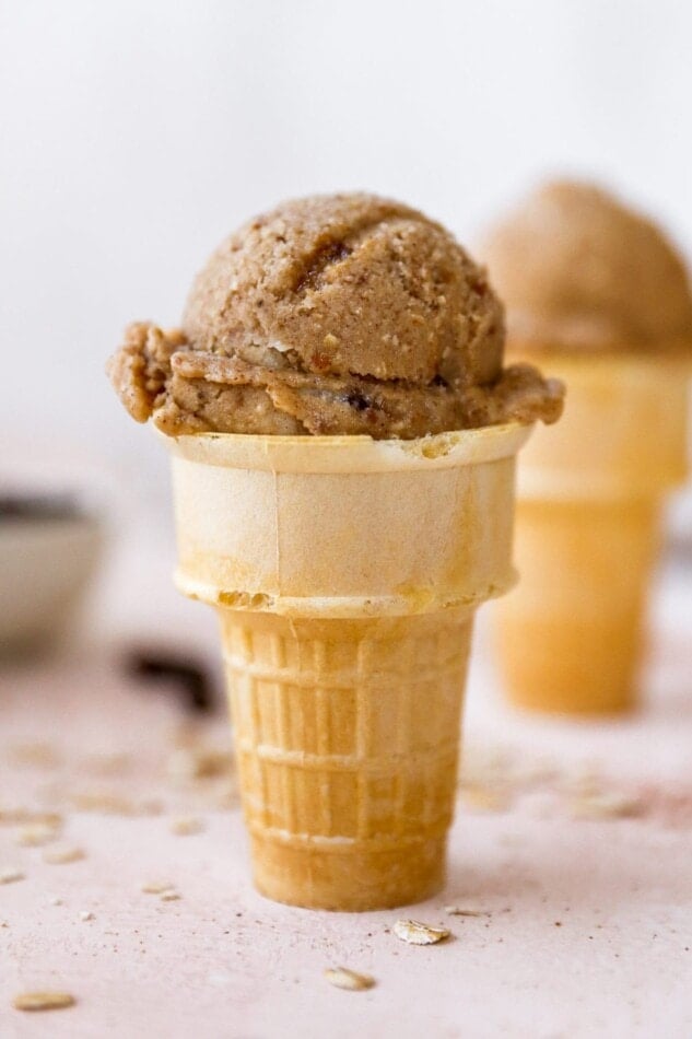 Scoop of oatmeal raisin banana ice cream in a cake cone.