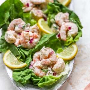 Shrimp salad served on lettuce cups. Lettuce cups are on a serving platter.