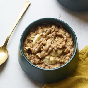 Bowl of banana walnut baked oatmeal. A spoon and napkin are next to the bowl.