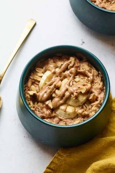 Bowl of banana walnut baked oatmeal. A spoon and napkin are next to the bowl.