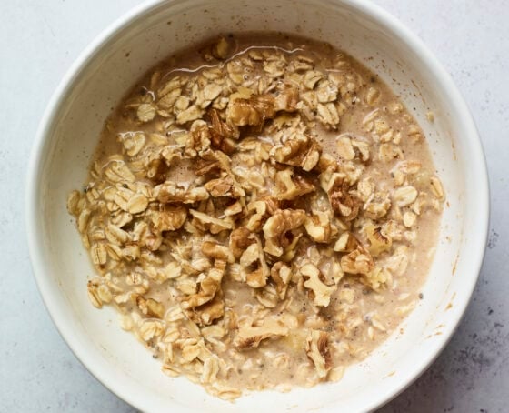 Mixing bowl with mixture to make banana walnut baked oatmeal.