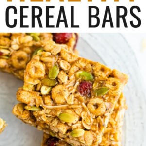 Cereal bars studded with dried cranberries and seeds on a plate.