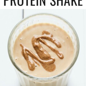 Peanut butter protein shake in a glass topped with a peanut butter drizzle.