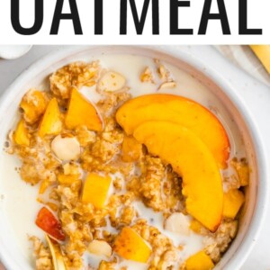 Peaches and cream oatmeal in a white bowl with fresh peaches and oat milk on top.