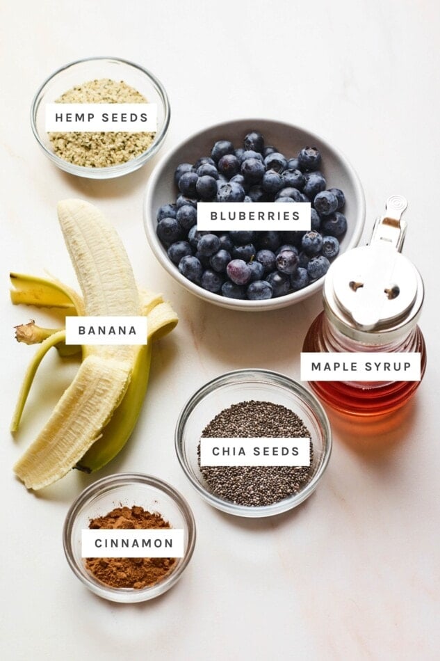Hemp seeds, blueberries, maple syrup, chia seeds, banana and cinnamon measured out.