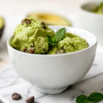 Bowl of avocado ice cream garnished with fresh mint.