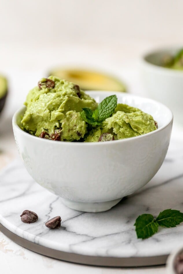 Bowl of avocado ice cream garnished with fresh mint.