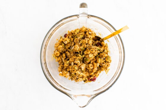 Cereal bar mixture in a mixing bowl with a spoon.