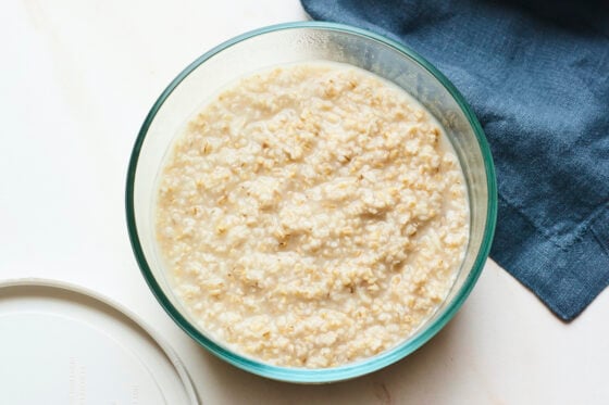 Glass food storage container with creamy steel cut oats.