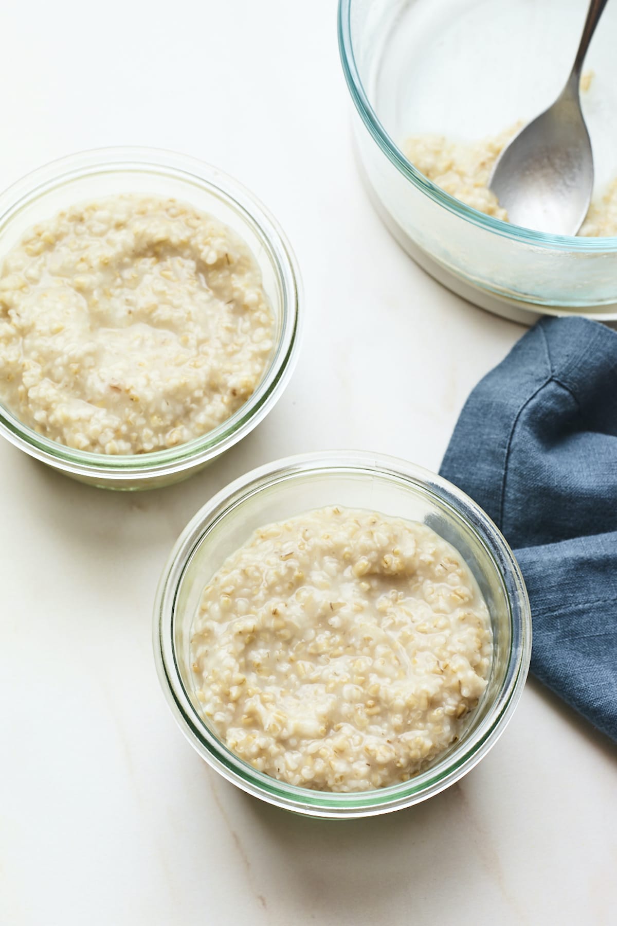Glass food storage containers with creamy steel cut oats.