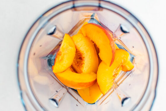 Fresh peaches in a blender, overhead shot.