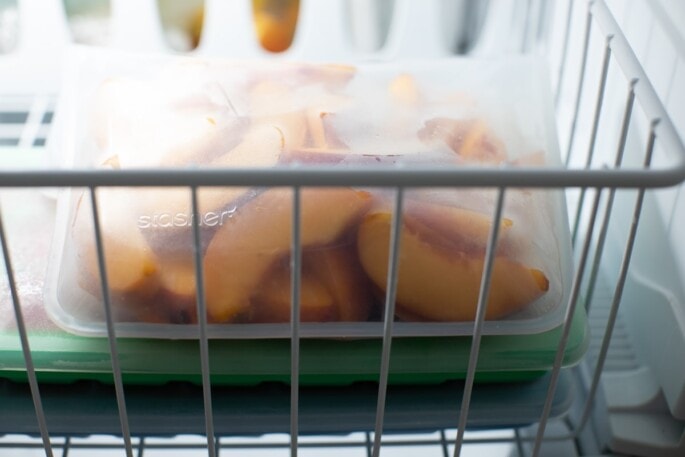 Peaches in a reusable freezer bag in the freezer.