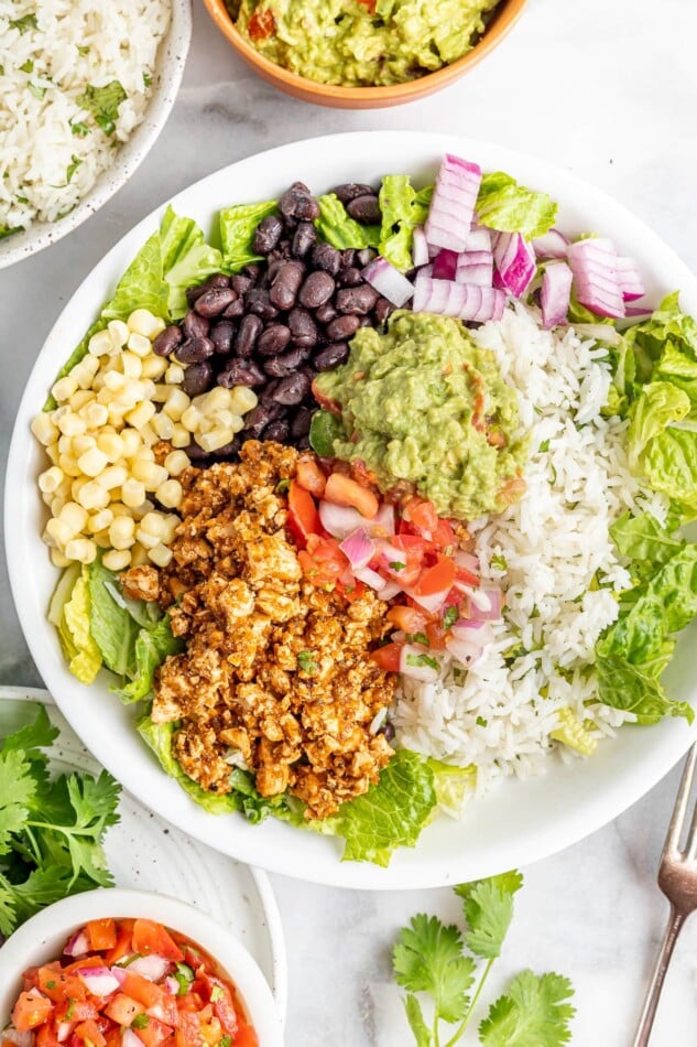 Burrito bowl made with sofritas, black beans, corn, salsa, guacamole, rice, lettuce and romaine.