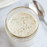 Mason jar of vegan ranch dressing. A spoon is to the side.