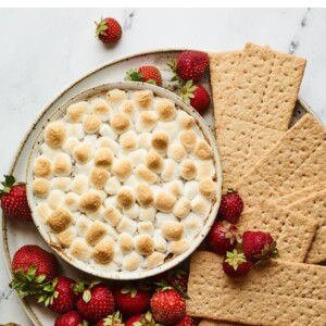 S'mores dip plated with strawberries and graham crackers for dipping.