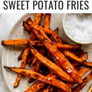 A plate of air fryer sweet potato fries with a ramekin of salt.
