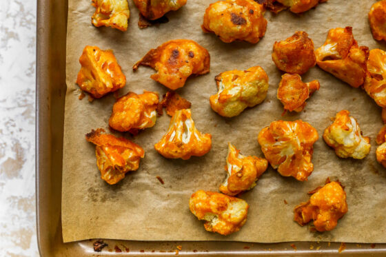 Cauliflower wings on a baking sheet lined with parchment paper.