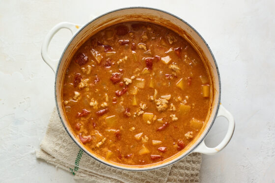 Broth, ground turkey, and vegetables in a large pot.