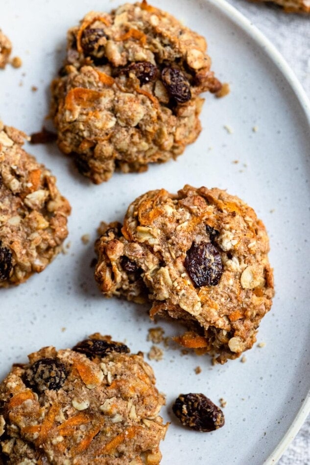 An over-head shot of a plate of carrot cake breakfast cookies. One of the cookies had a bite taken from it.