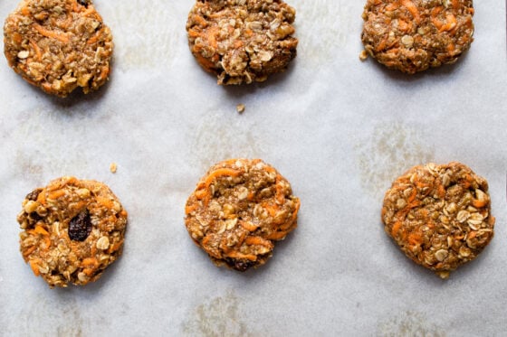 An over-head shot of six cookies spread across a sheet pan, ready to be baked.