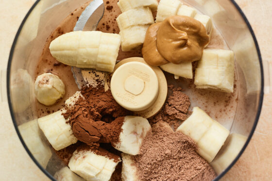 Banana, cocoa powder, chocolate protein powder, peanut butter and almond milk in a food processor.