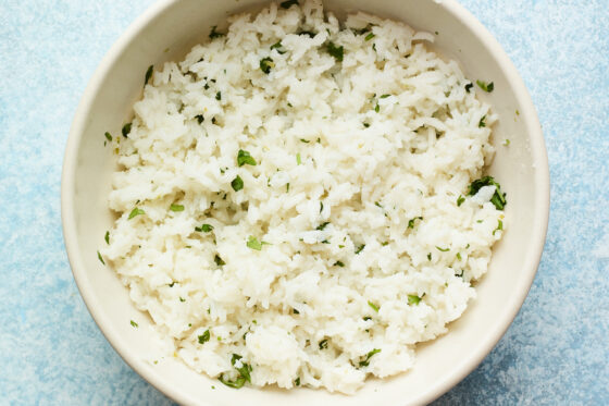 Overhead shot of a bowl with cilantro mixed into rice.