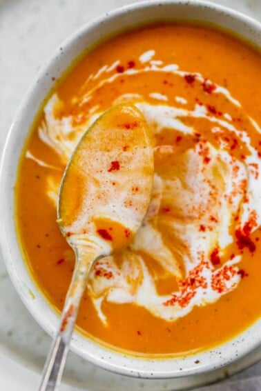 An overhead shot of a spoon ladling out some soup from a bowl.