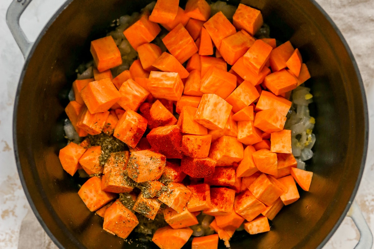 Overhead shot of ingredients for sweet potato soup in a large pot.