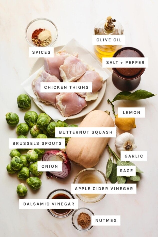 Ingredients measured out to make a chicken sheet pan meal: spices, olive oil, salt, pepper, chicken thighs, lemon, butternut squash, brussels sprouts, garlic, sage, onion, apple cider vinegar, balsamic vinegar and nutmeg.
