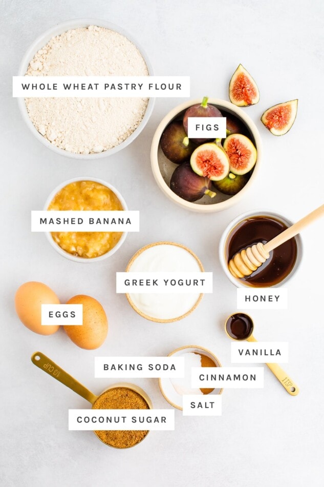 Ingredients measured out to make healthy fig bread: whole wheat pastry, figs, mashed banana, greek yogurt, honey, eggs, vanilla, baking soda, cinnamon, salt and coconut sugar.