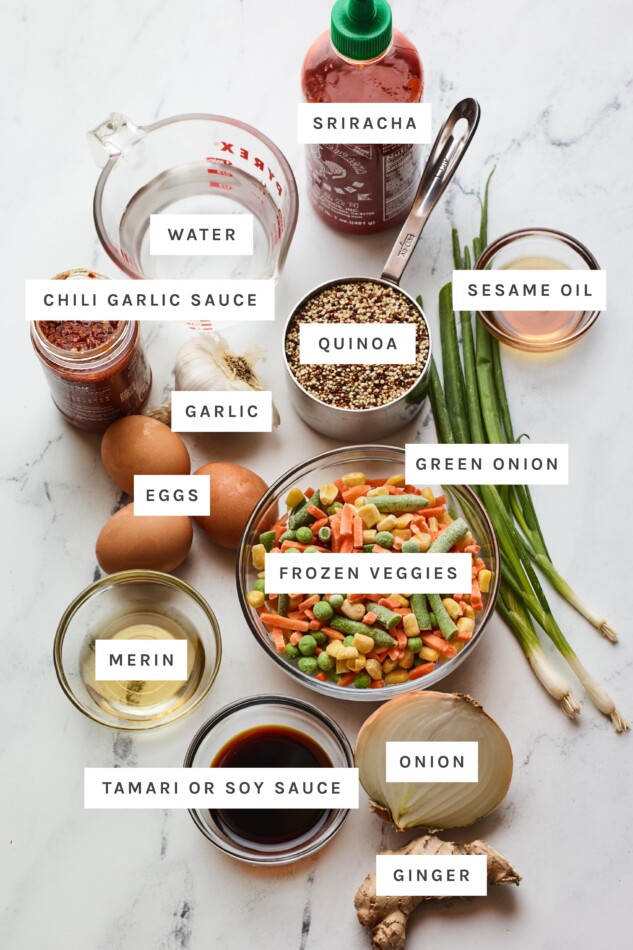 Ingredients measured out to make quinoa fried rice: sriracha, water, chili garlic sauce, quinoa, sesame oil, garlic, eggs, green onion, frozen veggies, merin, tamari, onion and ginger.