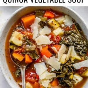 Overhead shot of quinoa vegetable soup with a spoon lifting some soup out of the bowl.