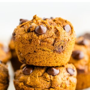 Two chocolate chip pumpkin muffins stacked on top of each other.