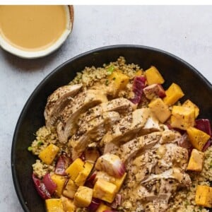 A plate of Za'atar chicken and vegetables over a bed of herbed couscous.